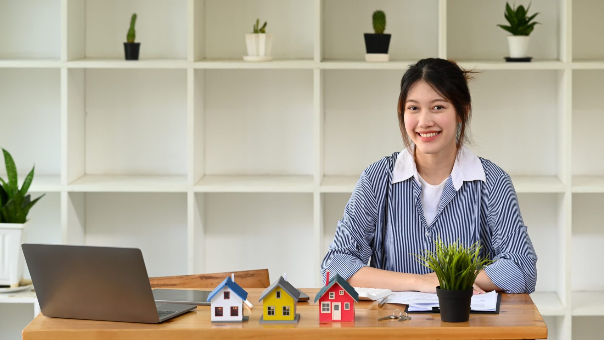 confident-real-estate-sitting-in-office-and-smilin-2022-07-12-13-42-39-utc-scaled-1