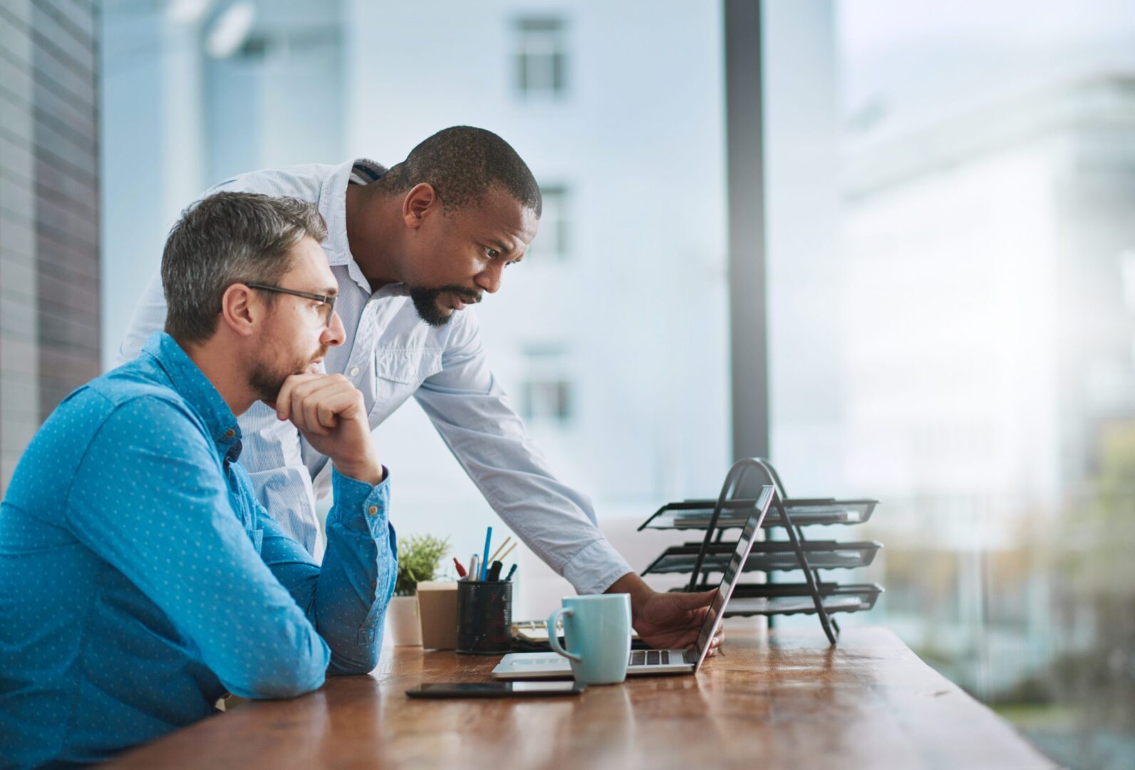let-me-take-look-shot-two-businessmen-working-laptop-their-office-scaled-1