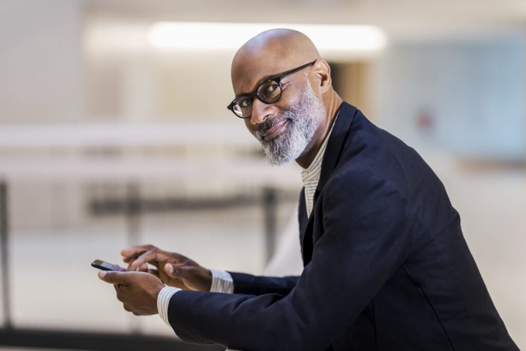 portrait-of-smiling-mature-businessman-with-cell-p-2022-03-08-01-20-14-utc-scaled-1